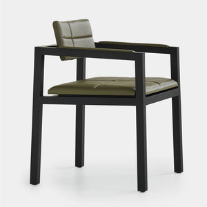 A side view of a designer dining chair created in solid wood stained black paired with an olive green leather seat and back