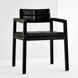 Four solid wood legs hold up a set modern armchairs crafted in black leather 